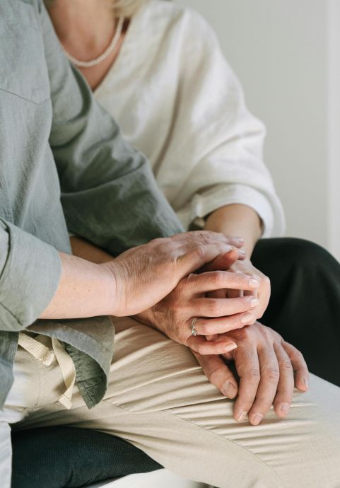 Close-up of a couple holding hands, symbolizing love and togetherness in a serene setting.